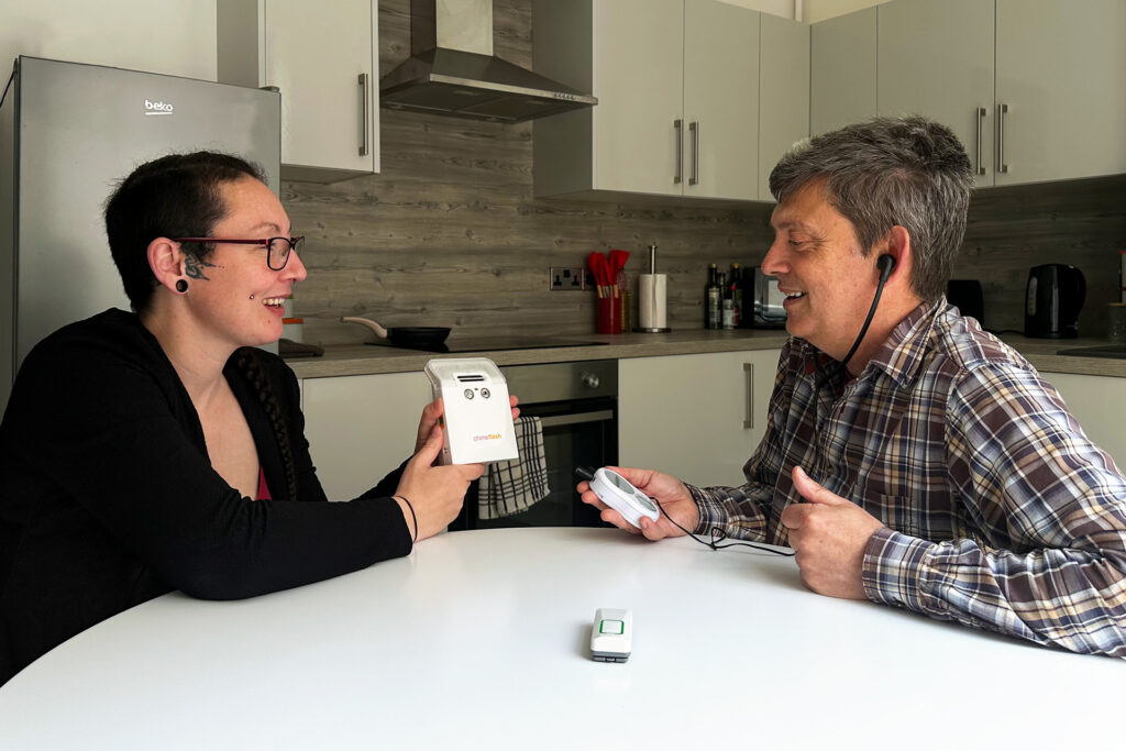 Lauren, our post diagnostic advisor demonstrating wireless flashing doorbell which can set to very loud. Client is hard of hearing and using a personal listener.